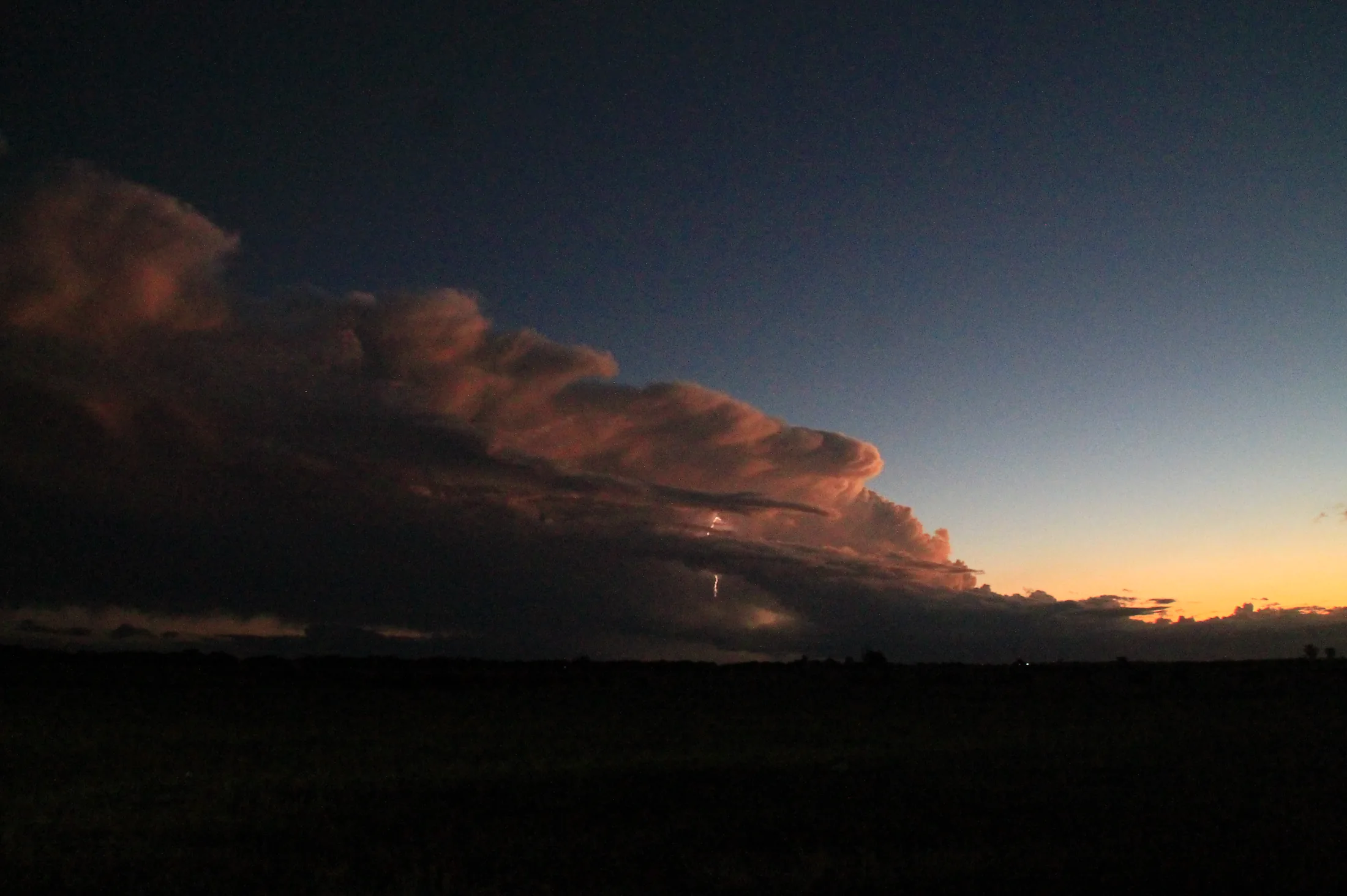 Nube de tormenta al atardecer con un relámpago distante